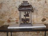 une petite table sur laquelle se trouve une horloge, devant un mur de pierre