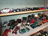 de nombreuses petites voitures et de nombreux petits camions sur une étagère dans une pièce