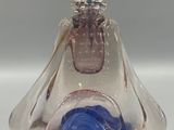 a glass figurine of a woman with a hat on top of her head