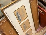 a lot of framed art on the floor in a room