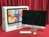 un écran d'ordinateur et un clavier posés sur une table rouge