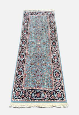 un tapis bleu à motifs floraux et à franges