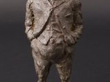 statue d'un homme en costume et chapeau, debout sur un rocher