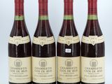 four bottles of wine are lined up on a white surface