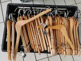a lot of wooden clothes hangers in a black container