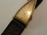 une photo d'une montre en or avec un bracelet en cuir noir