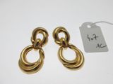 une paire de boucles d'oreilles dorées sur fond blanc