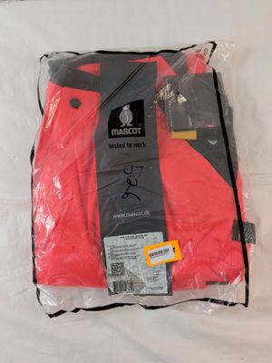 un gros plan sur une chemise rouge emballée dans du plastique, posée sur un lit