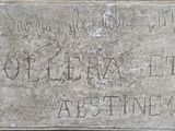une plaque en pierre fixée sur le mur d'un immeuble et sur laquelle figurent des inscriptions