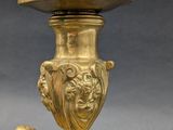 an antique brass candle holder with chers and angels on the base