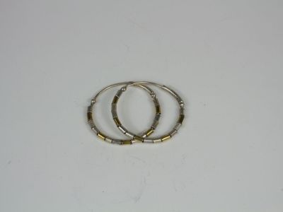 two silver and gold rings on a white surface