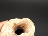 a hand holding a donut with a hole in it