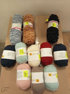 plusieurs pelotes de laine posées sur une boîte en carton