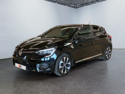 La voiture noire est garée dans une grande pièce aux murs blancs.