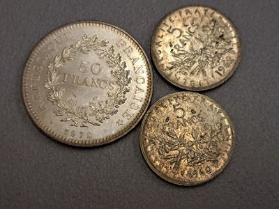 trois pièces d'argent posées les unes à côté des autres sur une table