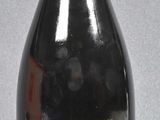 a black bottle with a red lid sitting on a table