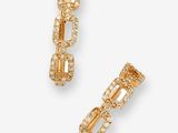 une paire de boucles d'oreilles en or serties de diamants sur fond blanc