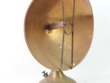 a small brass object on a metal stand on a white surface