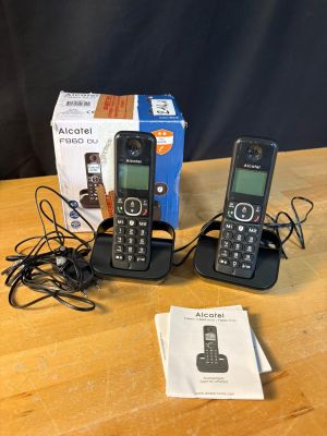 three cell phones are sitting on a table with a box on the table