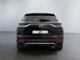 the rear end of a black suv parked in a white room