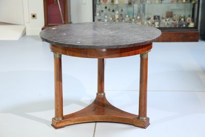a small table with a marble top on a white floor