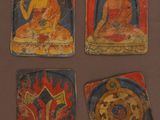 quatre tableaux représentant des bouddhas sont exposés sur un fond marron