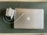 un ordinateur portable Apple et un chargeur posés sur la table