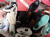 de nombreuses paires de chaussures dans un panier posé par terre