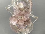 a glass figurine with a pink flower on it