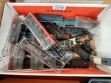une boîte contenant un assortiment de petits trains posée sur une table