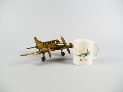 un petit avion miniature à côté d'une tasse de café