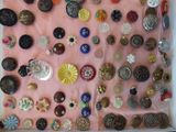 a picture of a display of buttons on a pink cloth