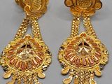 a pair of gold earrings with red and white stones