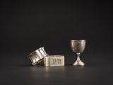 deux coupes en argent et une coupe en argent posée sur une surface noire
