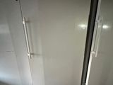 two white refrigerators sitting next to each other on the floor