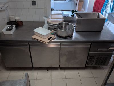 stainless steel counter top in a commercial kitchen with pots and pans on it