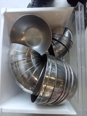 beaucoup de bols et de casseroles en métal dans une boîte blanche