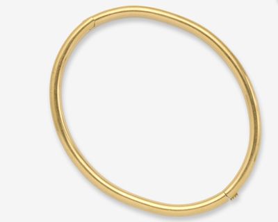gros plan d'un bracelet en or sur fond blanc