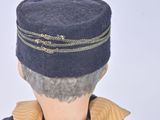 a doll that is wearing a hat and holding a cell phone