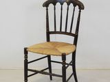 a black chair with a wooden seat and a wicker seat