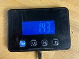 a digital clock on a table with a charger