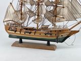 a wooden model of a sailing ship on a stand