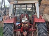 a tractor that is parked next to a pile of hay
