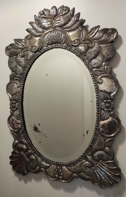 miroir ovale argenté orné de feuilles tout autour du bord