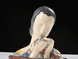 une figurine représentant une femme en prière, posée sur une assiette