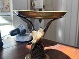 a bird on a pedestal on a table in a room
