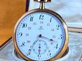 une montre de poche en or posée dans un écrin sur une table