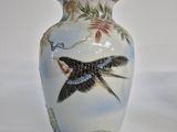 a white vase with a bird painted on it