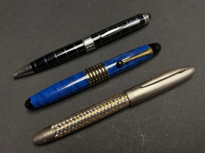 Trois types de stylos différents sont alignés sur une table