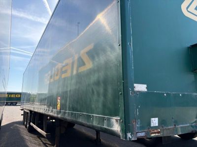 un gros camion vert garé sur le bord de la route